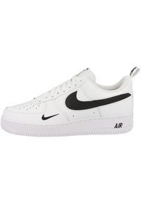 Sneakers bianchi in pelle con logo Swoosh nero di Nike. Presentano una superficie texturizzata, punta perforata e una robusta suola in gomma con il marchio "AIR".
