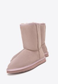 Pair of mid-calf light pink suede boots with flat rubber soles and soft, fluffy lining visible at the top edges.