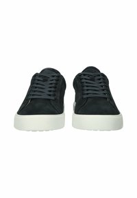 Schwarze Wildleder-Sneaker in niedriger Form mit dunklen Schnürsenkeln und dicken weißen Gummisohlen, von vorne auf weißem Hintergrund zu sehen.