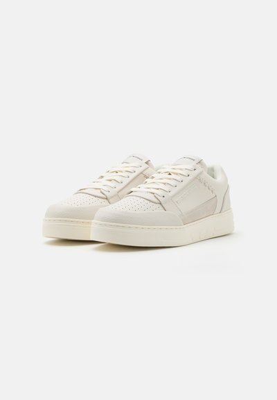 Baskets avec une tige en cuir crème à texture perforée, des lacets plats et une semelle en caoutchouc épaisse. Accents latéraux dans une teinte plus claire.