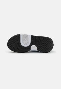 Svart och vit sneakersula med detaljerade mönster och en logotyp, framför en enkel vit bakgrund.