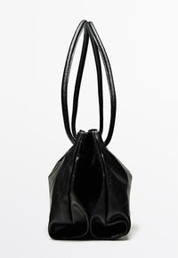 Borsa a tracolla in pelle nera con due manici lunghi, bordi morbidi e un design piegato alla base, caratterizzata da una texture liscia e uno stile minimalista.