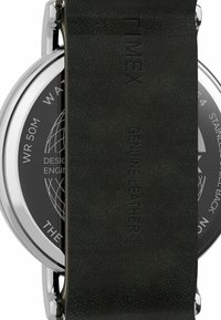 Montre Timex avec un bracelet en cuir véritable noir et un boîtier en acier inoxydable, présentant un cadran noir avec des marqueurs blancs et une résistance à l'eau jusqu'à 50 mètres.