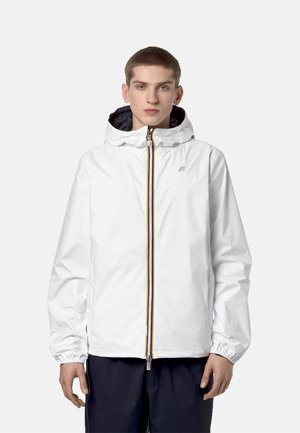 Giacca leggera bianca con chiusura a zip frontale, polsini elasticizzati e cappuccio. Presenta una zip e un logo di colore contrastante sul petto.
