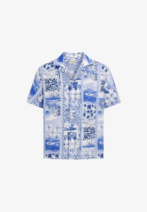 Chemise à manches courtes boutonnée avec des motifs côtiers et floraux bleus et blancs, comprenant des dauphins, des bâtiments, des palmiers et des motifs géométriques.