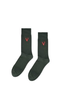 Ciemnozielone skarpetki z miękkiej tkaniny z czerwonym haftowanym logo głowy jelenia u góry. Klasyczny wzór z prążkowanym ściągaczem dla wygody.