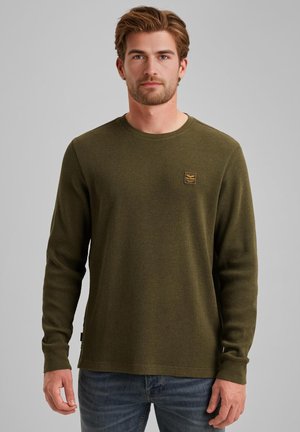 Chemise à manches longues vert olive en tissu texturé, avec un col rond, un petit logo brodé sur la poitrine et une coupe décontractée.