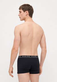 Schwarze Baumwoll-Boxershorts mit einem weichen, elastischen Bund, auf dem der Text "PIER ONE" in Weiß steht. Schnitt und Design sorgen für eine enganliegende Passform.