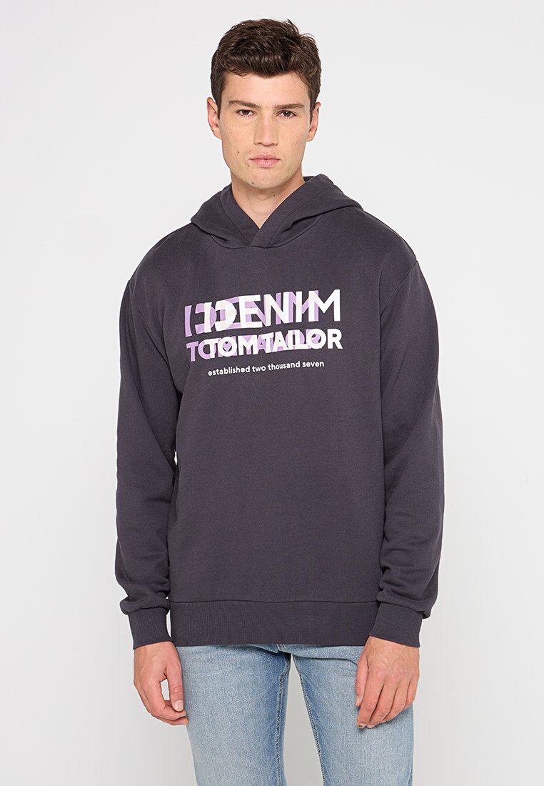 Felpa grigia scura con un design grafico frontale che presenta un testo stratificato in bianco e viola. Realizzata in tessuto morbido, con cappuccio regolabile e polsini a costine.