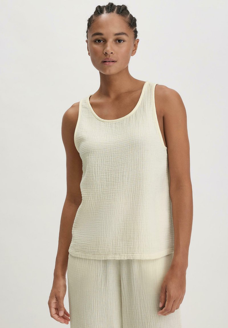 Cremfarbener Tank-Top aus einem weichen, strukturierten Stoff mit einem subtilen Kräuselungsmuster. Rundhalsausschnitt und ärmelloses Design.