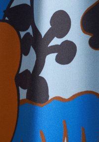 Tessuto con uno sfondo blu e design di piante astratte in marrone e nero, che evidenzia una texture liscia e colori vivaci.