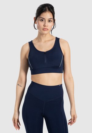 Marine sports-bh med lynlås foran, bredde stropper og reflekterende detaljer. Har en tætsiddende design og glat tekstur, kombineret med højttaljede leggings.