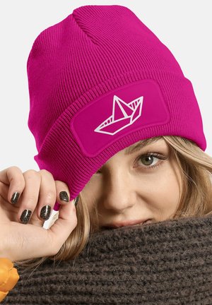 Fuchsia knit beanie with a textured finish, featuring a white paper boat graphic on a rectangular patch, snugly fitting the head.