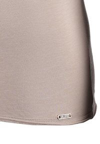 Lichtbeige tanktop van een gestructureerde stof. Kenmerkt zich door een klein logo-label nabij de zoom en een gladde, aansluitende pasvorm.