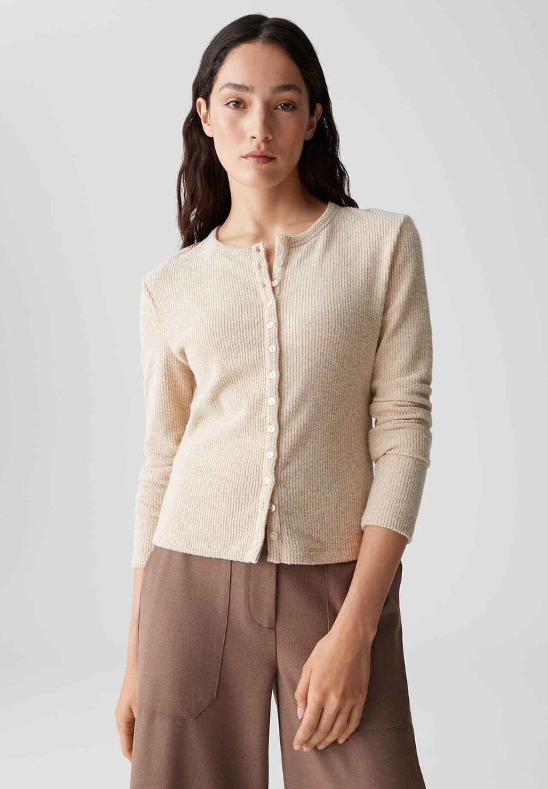 Beige gerippter Cardigan mit rundem Halsausschnitt und Knopfverschluss, ausgestattet mit einem strukturierten Stoff und schmalen langen Ärmeln.