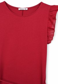 T-shirt rossa realizzata in tessuto morbido, con scollatura rotonda e dettagli arricciati sulle maniche corte. La parte superiore ha una vestibilità rilassata.