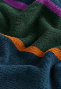 Mnohobarevná pletená látka se sytě zelenými, námořnickými modrými, oranžovými a fialovými pruhy. Měkká textura s viditelným vzorem tkaní a jemným leskem.