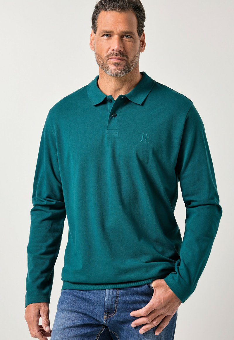 Błękitnozielona koszulka polo z długim rękawem i kołnierzykiem na guziki, wykonana z miękkiego materiału. Posiada subtelne haftowane logo na piersi.