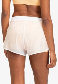 Witte lichtgewicht shorts met een doorzichtige uitstraling, voorzien van een elastische tailleband en witte afwerking langs de zoom. Ontworpen voor comfort en bewegingsvrijheid.