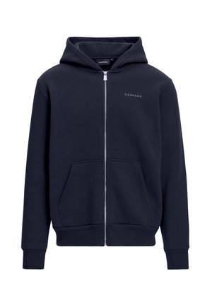 Navy huppari, joka on valmistettu puuvillasta ja jossa on vetoketjukiinnitys, etutaskut, ribbitut hihansuut ja helma, sisältää pienen logon rinnassa.