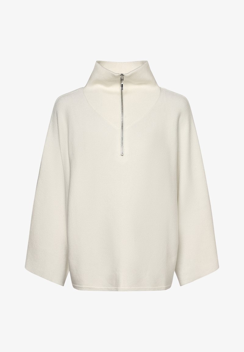Pull-over à manches longues de couleur blanc cassé avec un col montant côtelé et une fermeture éclair argentée à l'avant s'étendant jusqu'à mi-poitrine.