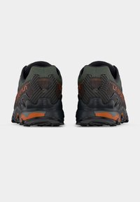 Μαύρα και σκούρα πράσινα αθλητικά παπούτσια με υφή στην επάνω επιφάνεια, αντίθετες πορτοκαλί λεπτομέρειες και ανθεκτική σόλα σχεδιασμένη για πρόσφυση και ανθεκτικότητα.