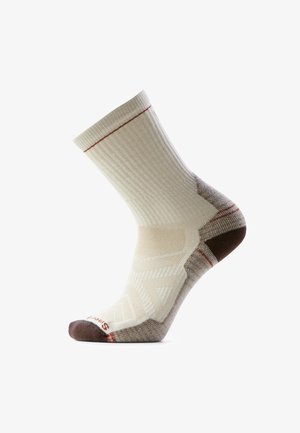 Beżowo-brązowa skarpeta do połowy łydki z prążkowanym ściągaczem i wzmocnionym obszarem pięty oraz palców, prezentowana na białym tle.