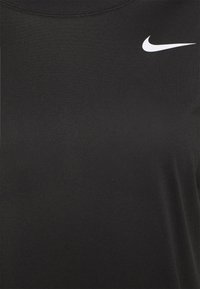 Camiseta deportiva negra de Nike con cuello redondo. Fabricada con un tejido suave, presenta un pequeño logo de swoosh blanco de Nike en la parte superior izquierda.