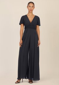 Marineblauwe jumpsuit met een diepe V-halslijn, korte fladdermouwen en geplooide wijde benen. Heeft een gecinched taille en een luchtige stof.