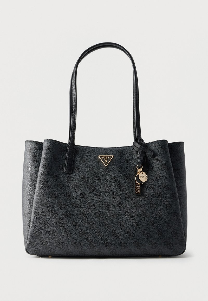 Sac cabas noir Guess avec doubles poignées, motif de logo subtil et breloques dorées de la marque suspendues près d'une poignée.