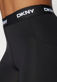 Leggings neri con il logo DKNY sulla fascia elastica in vita. Il tessuto è liscio, con un design aderente e cuciture piatte per il massimo comfort.