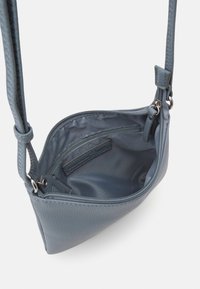 Modrá texturová kožená crossbody taška s hladkým vnitřkem, horním zipem a nastavitelným popruhem. Obsahuje vnitřní zipovou kapsu pro organizaci.