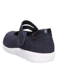 Navy slip-on shoe featuring a woven upper, two cut-out straps at the back, and a white rubber sole for contrast. Smooth and textured materials.