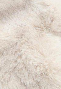 Umjetna krzna tkanina u mekoj, krem boji s dugom, pahuljastom teksturom. Površina prikazuje varijacije u dužinama vlakana i suptilan sjaj.