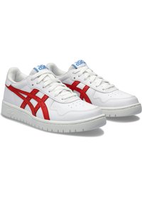 Białe skórzane sneakersy z czerwonymi akcentami, z teksturowaną powierzchnią, perforowanym noskiem i niebieskim logo na języku. Gumowa podeszwa.