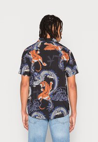Kortærmet skjorte i sort stof med et levende design af orange tigre og blå drager, med blå og hvide accenter.