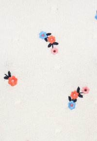 Weißer Strickstoff mit verstreuter floraler Stickerei in Blau, Pink und Orange. Mit kleinen erhabenen Punkten durchzogen.