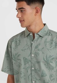 Korte mouwen overhemd met knopen in lichtgroene stof, voorzien van een all-over print van mariene en tropische motieven in donkerder groen.
