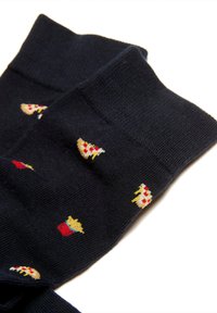 Calcetines negros con pequeños diseños bordados de rebanadas de pizza y cubos de palomitas, doblados y colocados en plano sobre un fondo blanco.