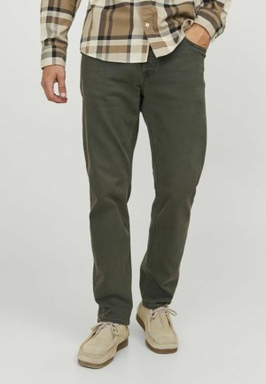 Pantalones verde oliva de corte ajustado, confeccionados en tela de mezcla de algodón. Presentan cinco bolsillos, lazos para cinturón y detalles de costura.