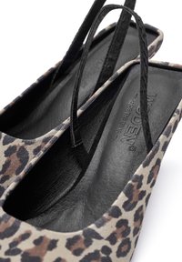 Leopardmönstrade slip-on skor med svarta läderremmar, fyrkantig tådesign och texturerad, vadderad svart inredning.