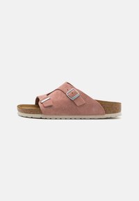 Sandal in suede rosa a slip-on con due cinturini regolabili con fibbie, sottopiede in sughero e suola in gomma bianca con texture a righe.
