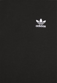 T-shirt in cotone nero con un piccolo logo Adidas bianco caratterizzato da un design floreale, su uno sfondo di una texture di tessuto liscia e uniforme.