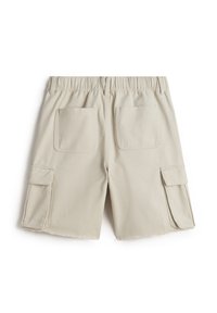 Beiga cargo shorts med elastisk midja, två bakfickor och två sidofickor med lock. Tyget har en texturerad yta med råa kanter.