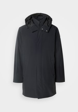 Parka nera impermeabile con cappuccio staccabile, chiusure a zip e a bottoni, tasche laterali e tessuto a trama liscia.