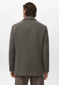 Cappotto grigio in lana con colletto strutturato, polsini con bottoni e design della schiena dritto. Texture liscia e stile di media lunghezza.