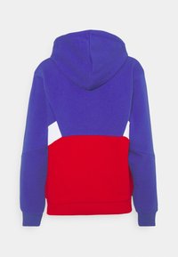Achteraanzicht van een hoodie met een paars bovenstuk, een rood onderstuk, witte zijpanelen, lange mouwen en een aangehechte capuchon.