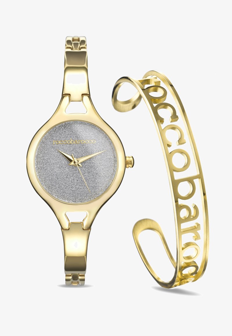 Goldfarbene Uhr mit einem silbernen, strukturierten Zifferblatt und Zeigern; passendes goldfarbenes Armband mit ausgeschnittenem Schriftzug-Design.