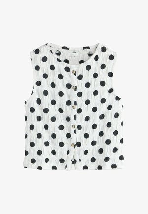 Weißes ärmelloses Oberteil mit Knöpfen, schwarzen Polka-Dots und einer strukturierten Stoffmusterung.