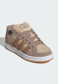 Tan ruskinds sneakers med beige paneler, featuring brune striber, polstret krave og tekstureret snøring. Hvid gummisål med gummibelægning.